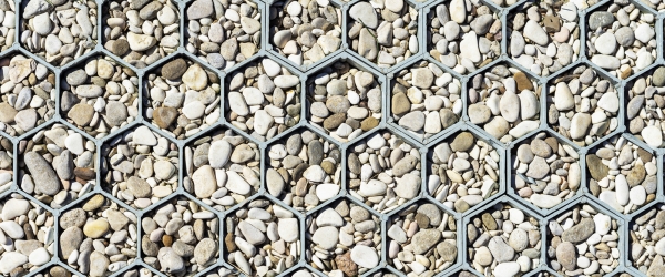 Background, texture of small pebbles surrounded by honeycomb grid