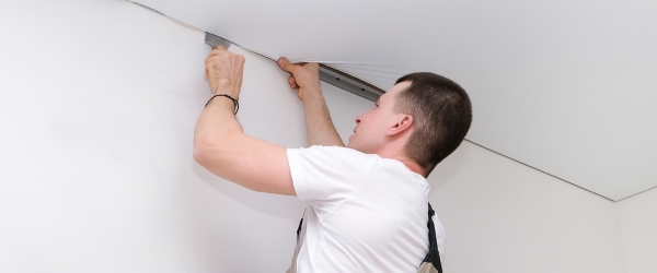 worker installs a stretch ceiling. Construction and renovation
